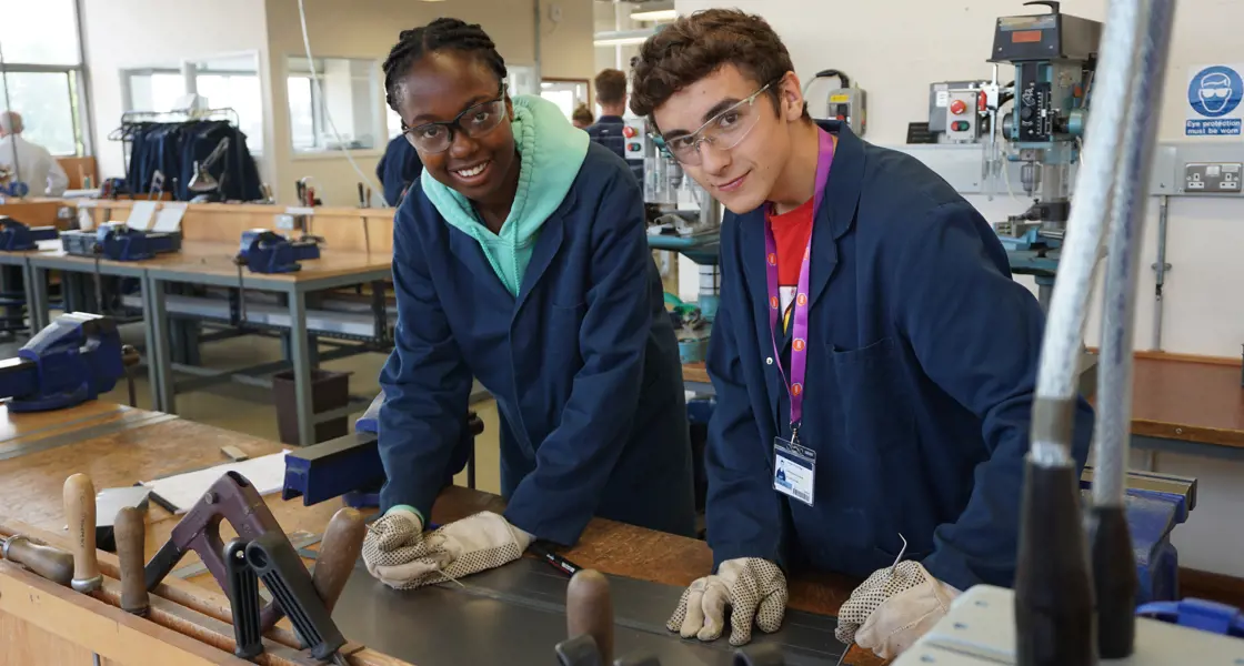 Two students wearing safety gear in laboratory workshop