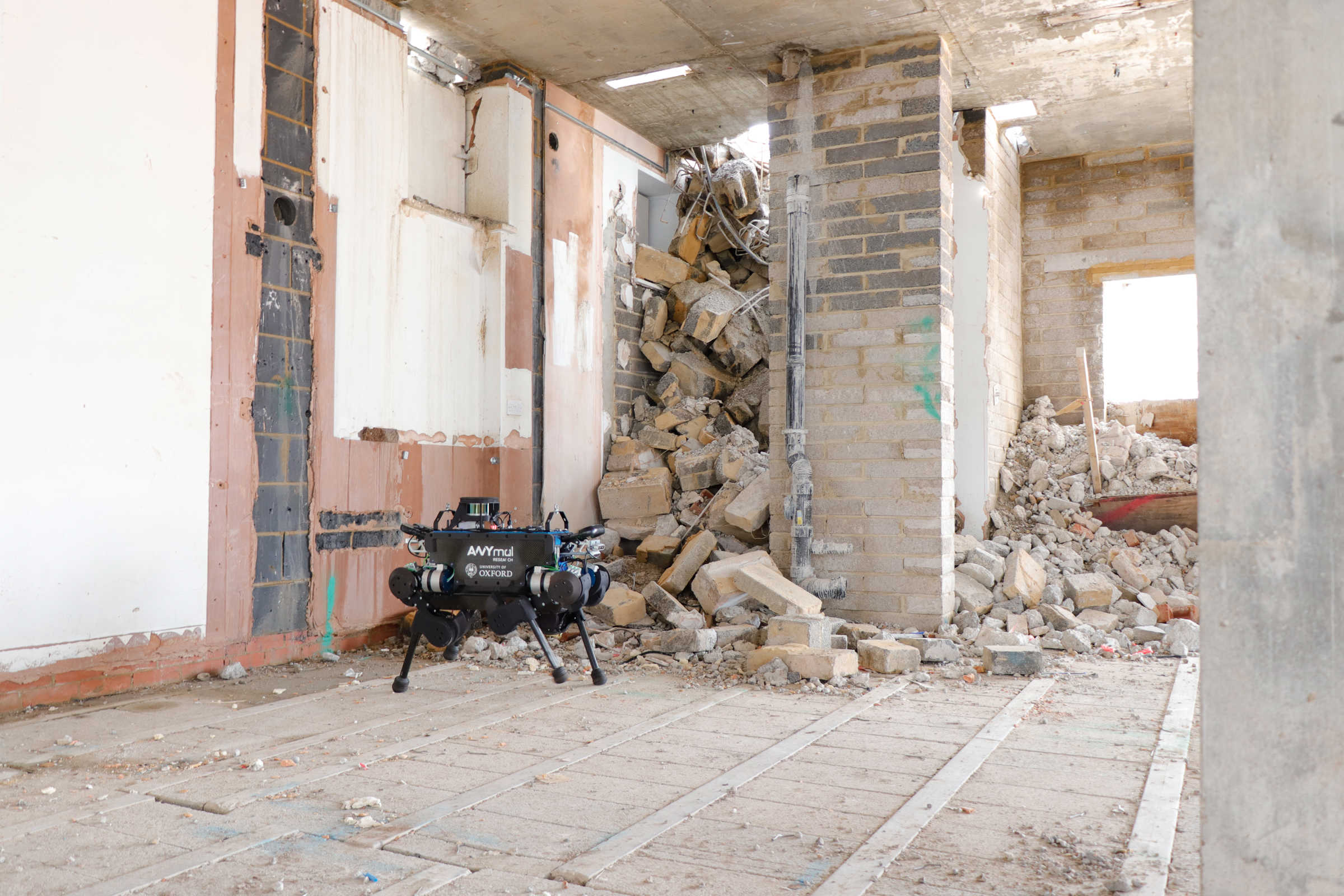 Blue ANYmal B robot in front of building rubble. 