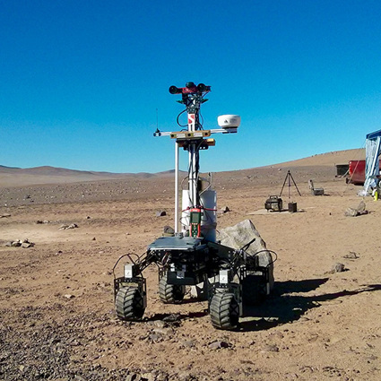 Space rover robot on open plain dirt environment. 