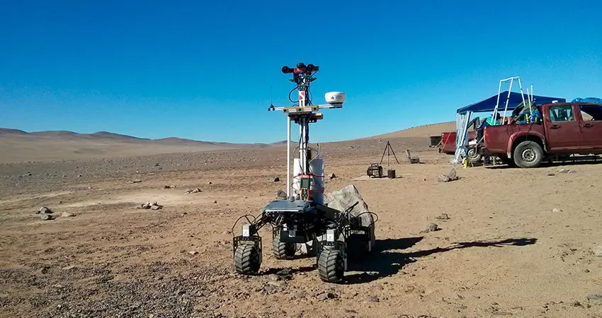 Space rover robot on open plain dirt environment.