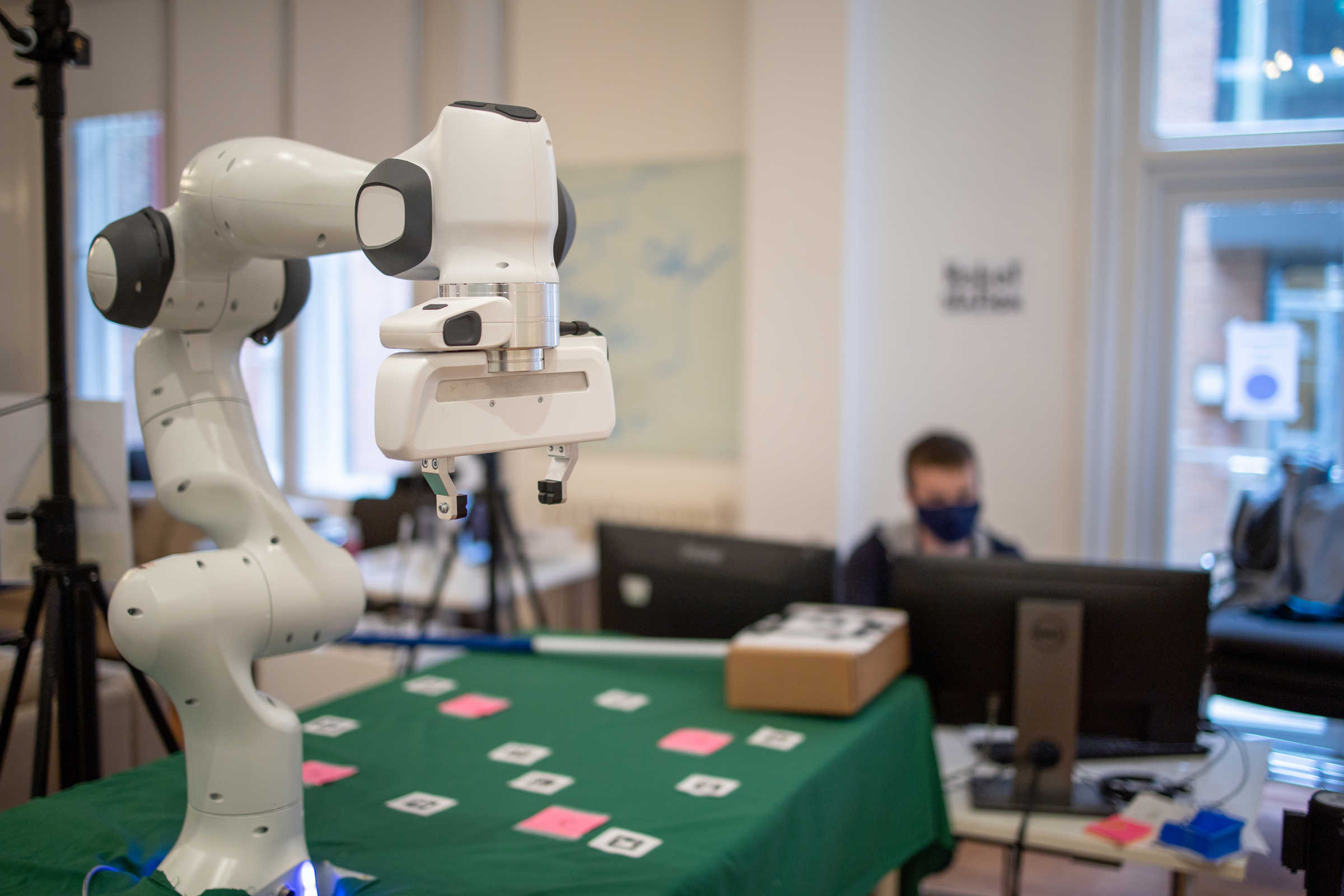 Panda robot arm on green table with cards.  