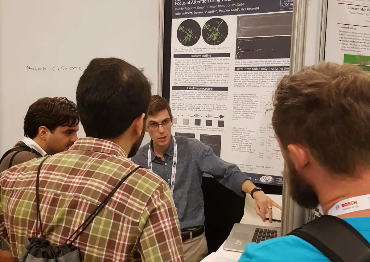 Participiants involved in discussions on posters during an evening drinks and poster session