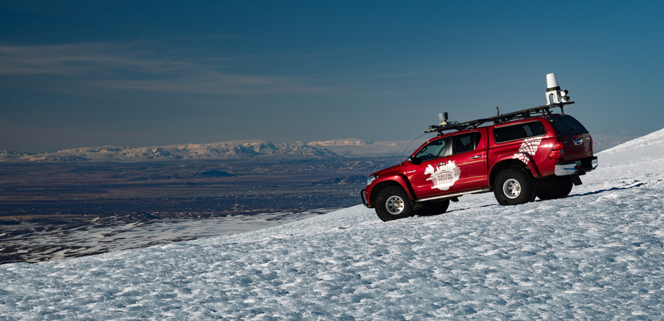 Red vehicle on glacier in Iceland for trails. 