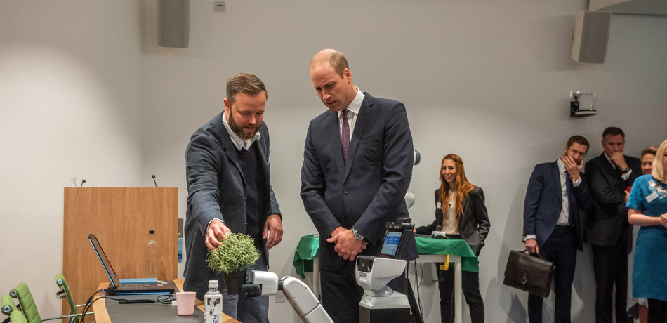 Duke Of Cambridge and Lars Kunze looking at the HSR Robot at Keble College.