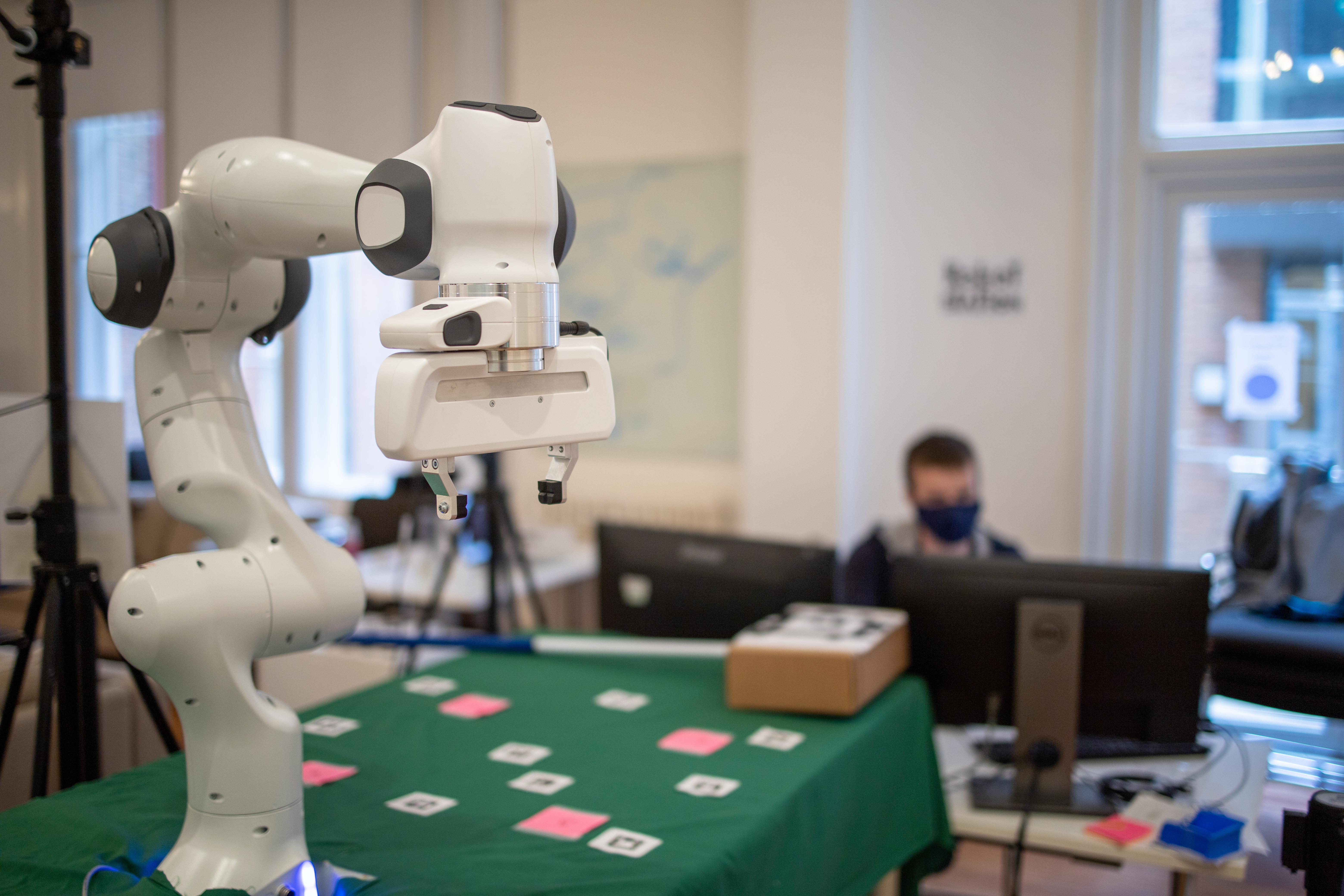 Panda robot arm on green table with cards.  