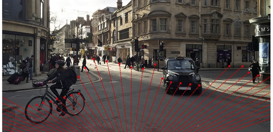 Person on bicycle and car in Oxford streets.