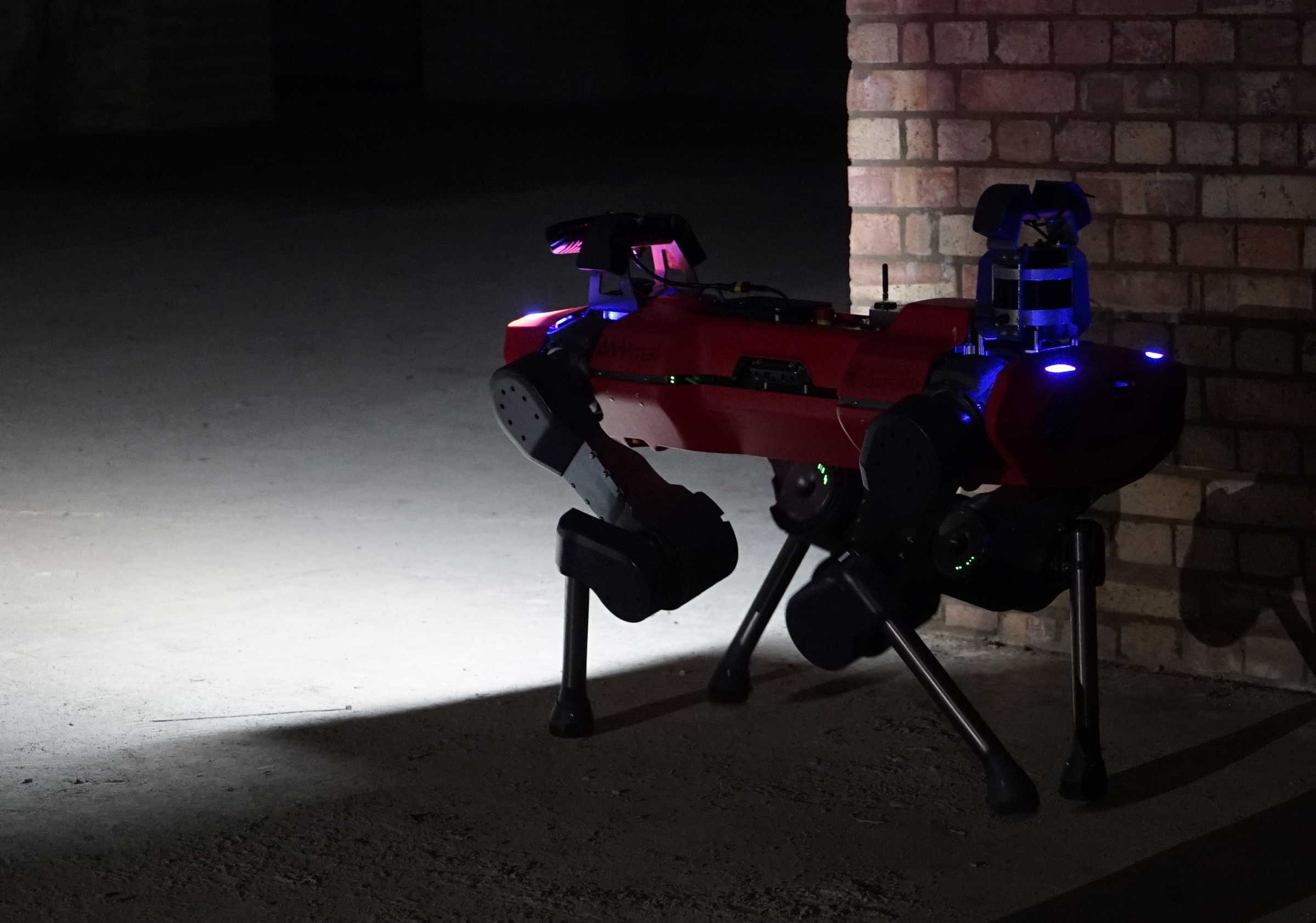 Red anymal c robot surveying dark underground site. 