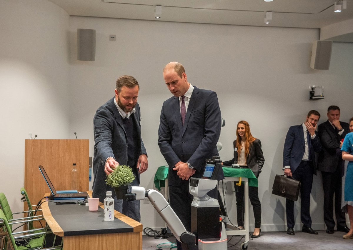 Duke Of Cambridge and Lars Kunze looking at the HSR Robot at Keble College. 